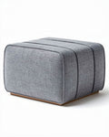 Hocker van grijs textiel met een afmeting van 45 x 45 x 40cm